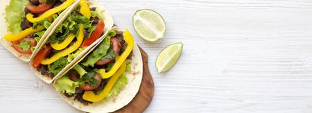 Beef tacos with salad and pepper on a white wooden backgrund, top view. Flat lay, overhead, from above. Copy space.の写真素材