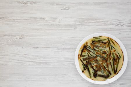 Overhead view, homemade korean Pajeon scallion pancake on a white plate on a white wooden background. Asian food. Flat lay, top view, from above.の写真素材