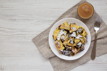 Homemade german Kaiserschmarrn pancake with apple sauce on a white wooden background, top view. Flat lay, overhead, from above. Copy space.の写真素材
