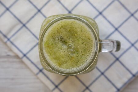 Homemade green cucumber apple smoothie in a glass jar, top view. Flat lay, overhead, from above....