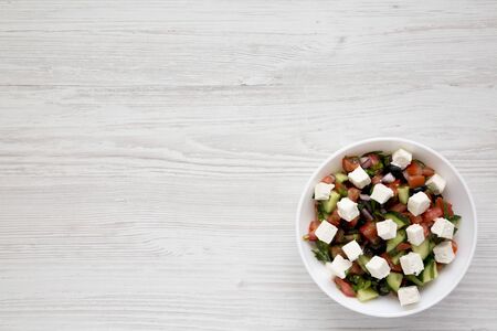 Homemade Shepards salad with cucumbers, feta and parsley in a white bowl, top view. From above, overhead. Copy space.の写真素材