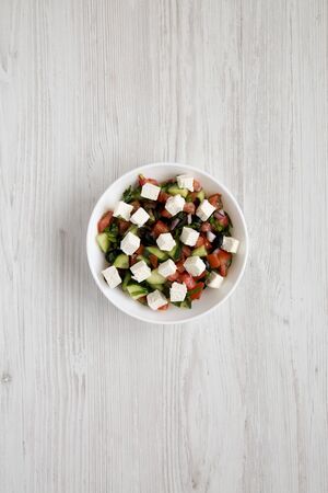 Homemade Shepards salad with cucumbers, feta and parsley in a white bowl, top view. From above, overhead, flat lay.の写真素材