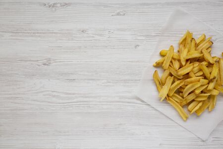 Homemade french fries on a white wooden background, top view. Flat  lay, overhead, from above. Copy...