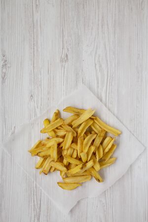 Homemade french fries with salt on a white wooden background, overhead view. Flat lay, top view,...