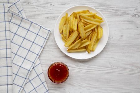 Homemade french fries with sour-sweet sauce on a white plate, top view. Flat lay, overhead, from...