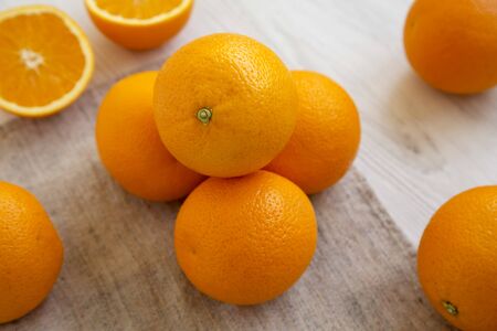 Fresh ripe organic oranges on a white wooden surface, low angle view. Close-up.