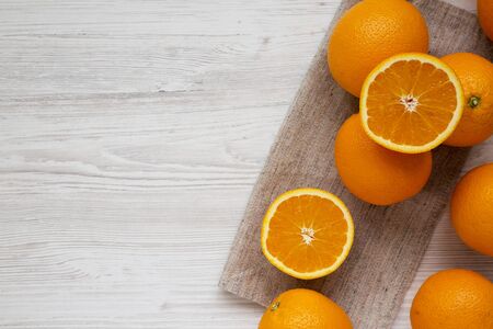 Fresh ripe organic oranges on a white wooden background, top view. Flat lay, overhead, from above. Space for text.の写真素材