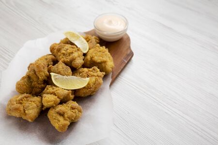 Homemade crispy japanese fried chicken Karaage on a rustic wooden board over white wooden background, low angle view. Copy space.の写真素材