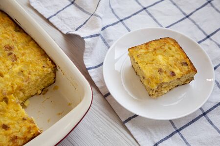 Homemade Cheesy Amish Breakfast Casserole on a white wooden surface, low angle view. Close-up.の写真素材