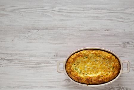 Homemade Cheddar Corn Pudding Casserole on a white wooden background, top view. Flat lay, top view, from above. Space for text.の写真素材