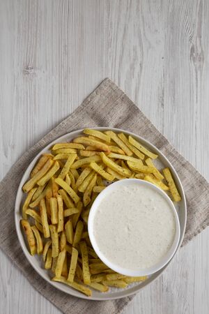 Homemade Crispy Ranch Fries on a gray plate on a white wooden surface, overhead view. Flat lay, top view, from above. Space for text.の写真素材