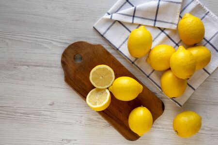 Ripe Yellow Organic Lemons on a white wooden surface, overhead view. Flat lay, top view, from above....