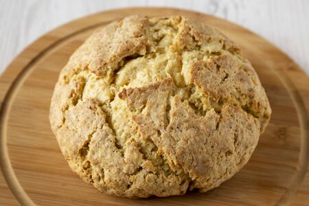 Homemade Irish Soda Bread on a round bamboo board, side view. Close-up.