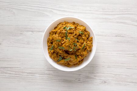 Homemade Chicken Tikka Masala in a white bowl on a white wooden surface, top view. Flat lay, overhead, from above.の写真素材