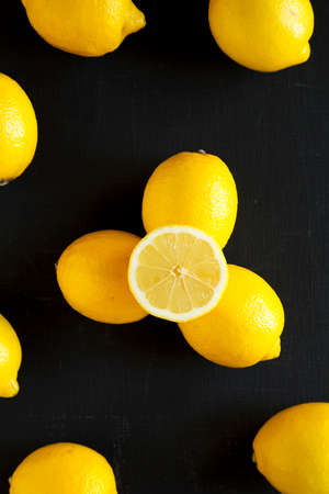 Ripe Yellow Organic Lemons on a black surface, top view. Flat lay, overhead, from above.