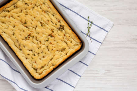 Home-baked Rosemary Garlic Focaccia Bread on baking tray, top view. Flat lay, overhead, from above....