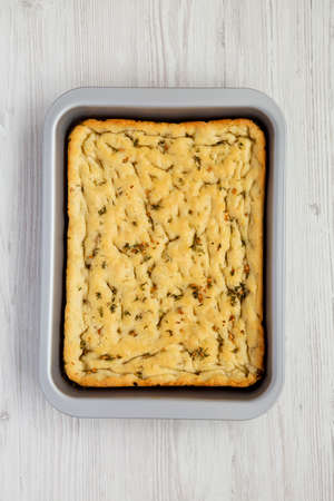 Home-baked Rosemary Garlic Focaccia Bread on baking tray, top view. Flat lay, overhead, from above.