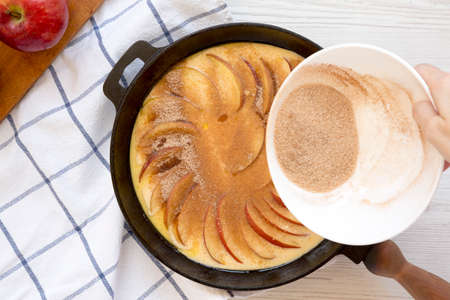 Cooking Apple Dutch Pannekoek Pancake on a white wooden surface, top view. Overhead, from above,...