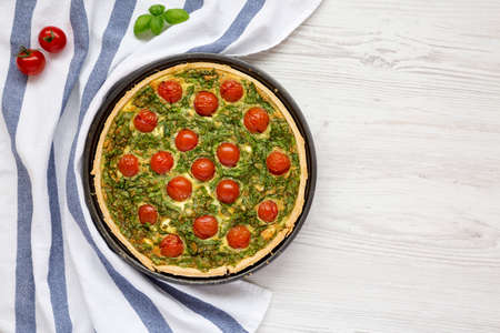 Homemade Spinach Quiche in a baking dish, top view. Flat lay, overhead, from above. Space for text.
