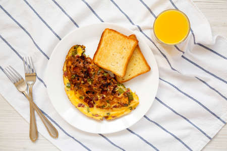 Homemade Denver Omelette on a white plate on cloth, overhead view. Flat lay, top view, from above.