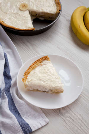 Piece of Homemade Tasty Banana Cream Pie on a white plate, side view.の写真素材