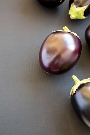 Raw Purple Eggplants on a black background, side view. Copy space.の写真素材