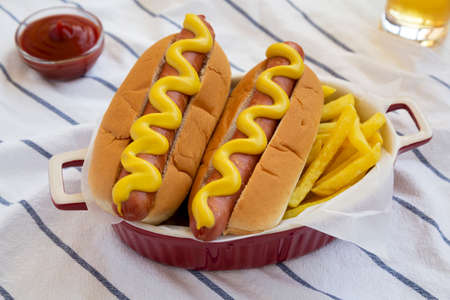 Homemade Mustard Hot Dog with French Fries on cloth, side view.の写真素材