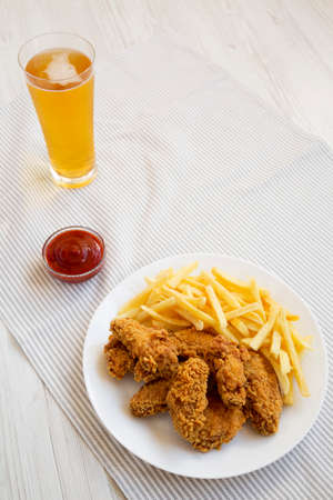 Homemade Crispy Chicken Wings and French Fries with ketchup and glass of cold beer, high angle view. Copy space.の写真素材
