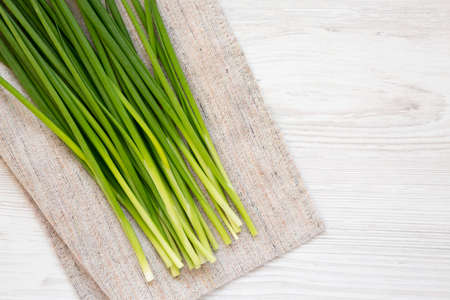 Raw Green Onions on a white wooden background, top view. Flat lay, overhead, from above. Copy space.