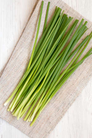 Raw Green Onions on a white wooden surface, top view. Flat lay, overhead, from above.の写真素材