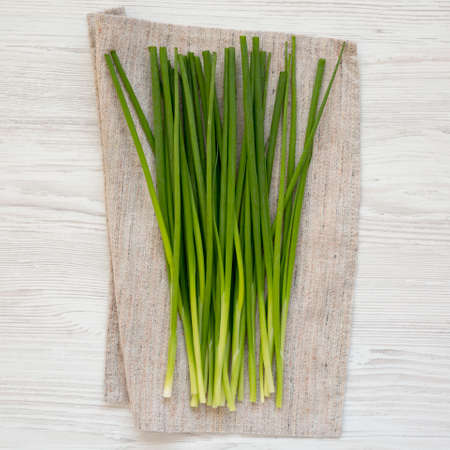 Raw Green Onions on a white wooden table, top view. Flat lay, overhead, from above.の写真素材