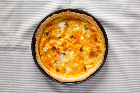 Homemade Bacon Quiche with Eggs and Cheddar Cheese on cloth, overhead view. Flat lay, from above, top view.の写真素材