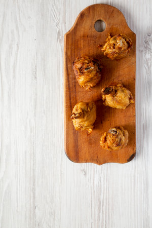Homemade Spicy Chicken Lollipop on a rustic wooden board on a white wooden surface, top view. Overhead, from above, flat lay. Copy space.の写真素材