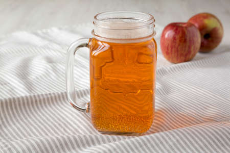 Hard Apple Cider Ale in a Glass Jar Mug on cloth, side view. Close-up.の写真素材