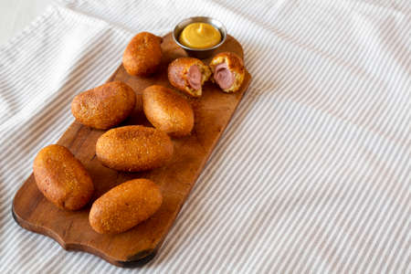 Homemade Mini Corn Dogs on a rustic wooden board, low angle view. Copy space.の写真素材