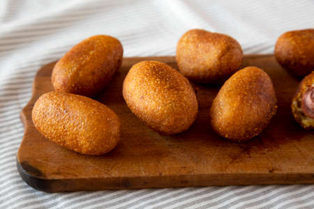 Homemade Mini Corn Dogs on a rustic wooden board, side view. Close-up.の写真素材