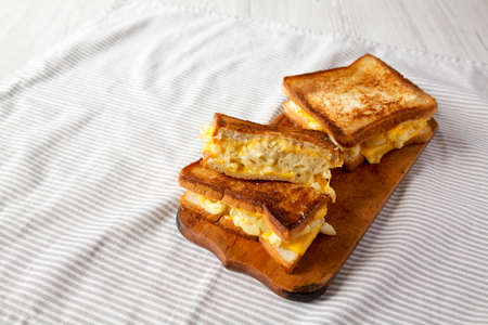 Homemade Grilled Macaroni and Cheese Sandwich on a rustic wooden board, side view. Copy space.