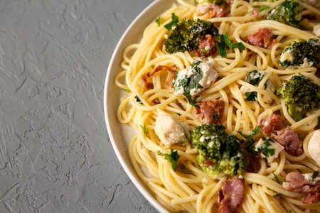 Homemade Chicken Bacon Broccoli Alfredo on a plate on a gray background, side view. Copy space.の写真素材