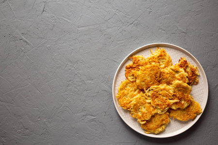 Homemade Potato Pancakes Latkes on a plate on a gray background, top view. Flat lay, overhead, from...