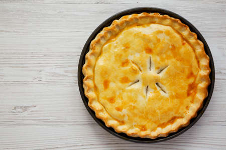 A Piece of Chicken Pot Pie on a white wooden surface, top view. Flat lay, overhead, from above. Space for text.の写真素材