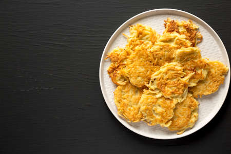Homemade Potato Pancakes Latkes with Apple Sauce and Sour Cream on a black background, top view. Flat lay, overhead, from above. Copy space.の写真素材