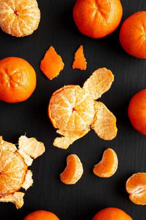 Raw Organic Mandarin Oranges on a black surface, top view. Flat lay, overhead, from above.の写真素材