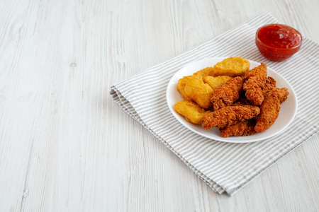 Homemade Nuggets and Chicken Tenders with Sweet and Sour Sauce on a white wooden background, side view. Space for text.の写真素材