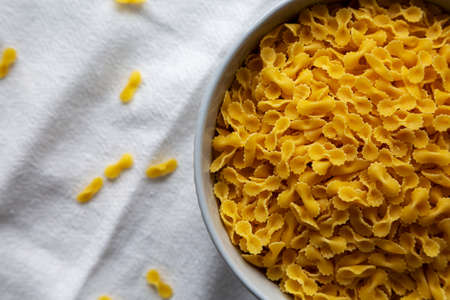 Healthy Dry Farfalline Pasta in a Bowl, top view. Flat lay, overhead, from above. copyspace.