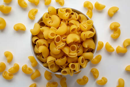Raw Dry Organic Pipe Rigate Pasta in a Bowl on white surface, top view. Flat lay, overhead, from above.の写真素材