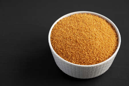 Brown Demerara Sugar in a Bowl on a black background, side view. copyspace.の写真素材