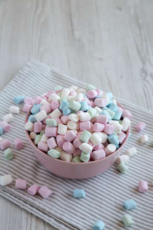 Rainbow Fruity Mini Marshmallows in a Pink Bowl, side view. copyspace.