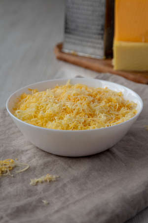 Shredded Mexican Cheese Mix in a White Bowl, side view.