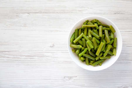 Steamed Green Beans in a White Bowl, top view. Overhead, from above, flat lay. copyspace.