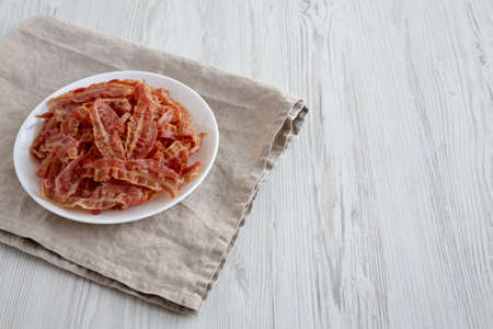 Crispy Fried Bacon on a white plate, side view. Space for text.の写真素材